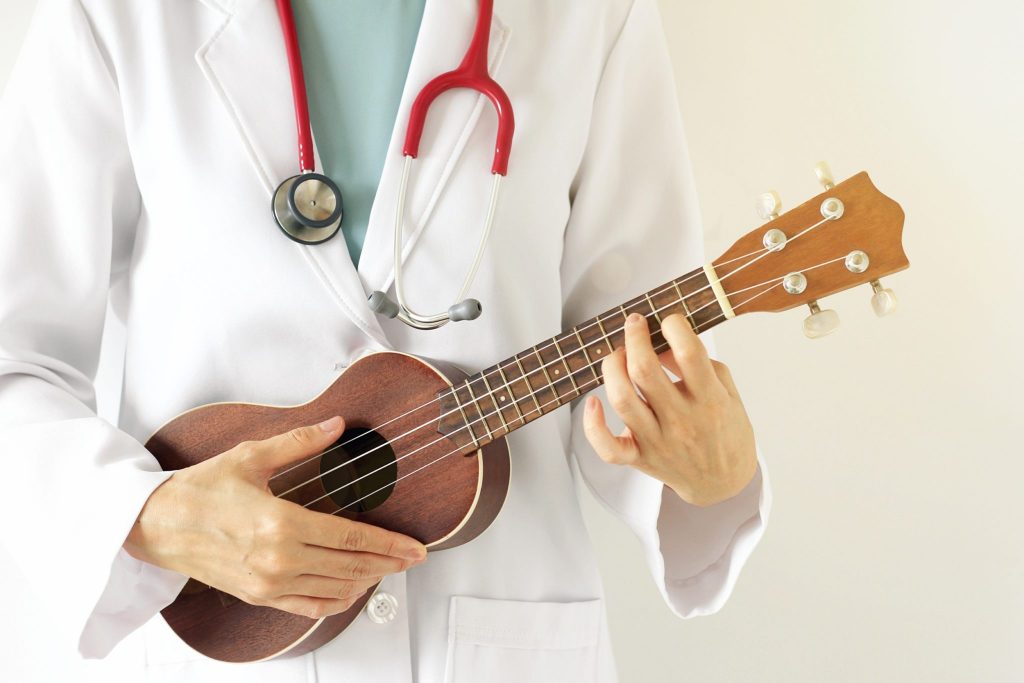 Doctor playing ukulele, Music therapy concept. (Selective Focus)