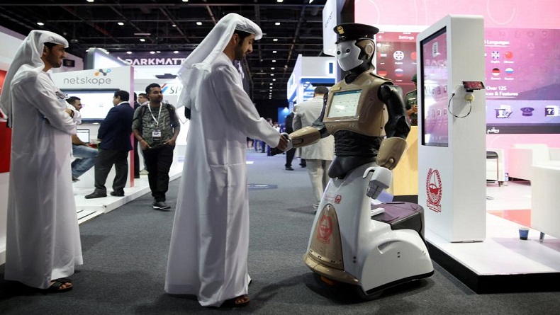 A visitor shakes hands with an operational robot policeman at the opening of the 4th Gulf Information Security Expo and Conference (GISEC) in Dubai, United Arab Emirates, May 22, 2017. Picture taken May 22, 2017. REUTERS/Stringer