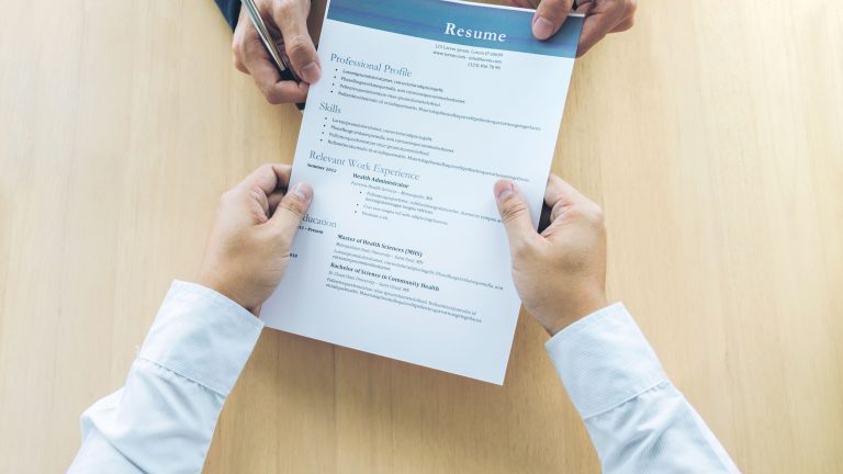 cropped-hands-of-business-people-holding-resume-on-table-in-office-944152896-5b256f2b0e23d90036493caa